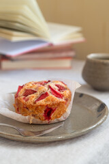 Homemade strawberry white chocolate muffins on handmade clay plate.
