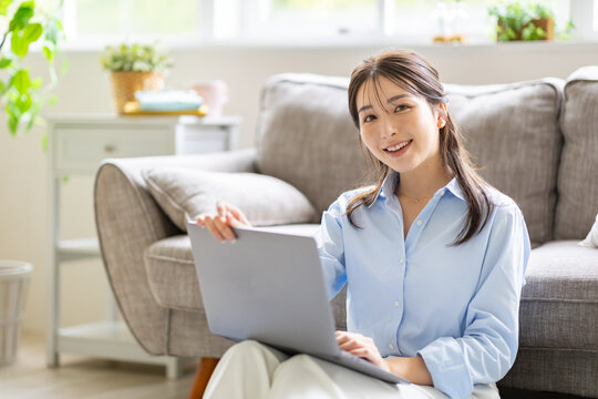 部屋でパソコンを見る女性
