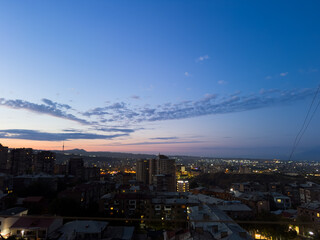 Fototapeta premium Morning and dawn over the city while everyone is asleep. Yerevan, Armenia. A city skyline with a beautiful blue sky. The sky is filled with clouds and the sun is setting