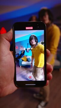 Behind the scenes POV shot of smartphone capturing teen boys dancing stylish synchronized choreography home creator setup and modern digital workflow
