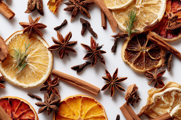 Mixed dried winter spices and citrus fruit slices flat lay isolated on white background. Top view of cinnamon, star anise and ingredients for mulled wine