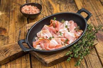 Uncooked bacon strips arranged with thyme on wooden board great for kitchen cooking advertising recipe blogs and menu design