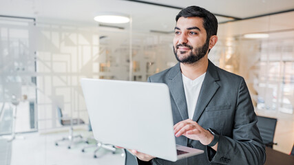 Business professional working on laptop in modern office