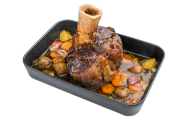 Slow cooked veal shank ossobuco style roasted with vegetables and gravy in baking tray on light background