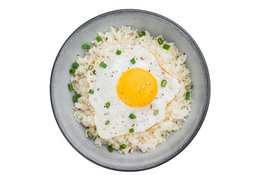 Crisp edged fried egg on soft steamed rice with sesame and pepper offering a rustic homemade breakfast full of warm flavors.