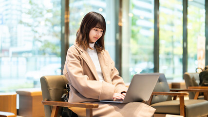 Fototapeta premium カフェでパソコンを使う女性