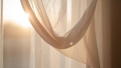 Showing sheer curtain panel forming knotted drape at window, with warm sunlight lens flare