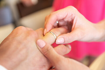 Bride Hand Sliding Wedding Ring Onto Groom Finger During Romantic Marriage Ceremony