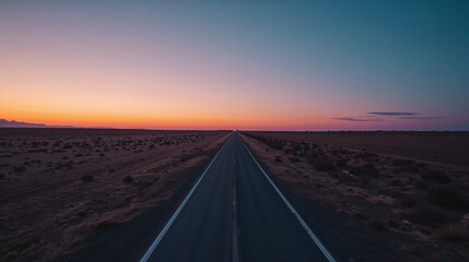 Stretching two-lane road cutting across desert plain at sunset, with dashed center lines
