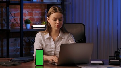Woman Working on Laptop with Green Screen Smartphone