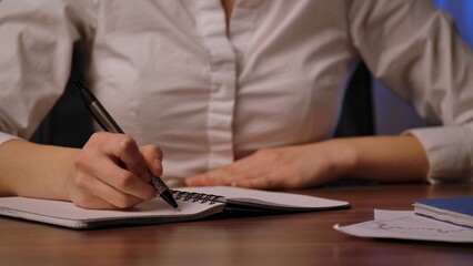 Fototapeta premium Close up of Woman Writing Notes in Notebook