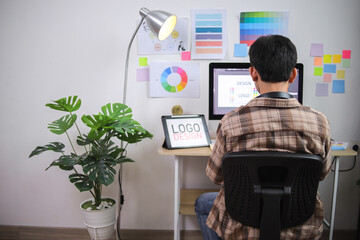 Young Graphic Designer Actively Creating Logo on Desktop Computer and Graphic Tablet in Office