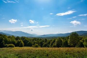 Obraz premium Wide Mountain Landscape With Green Forests And Bright Blue Summer Sky