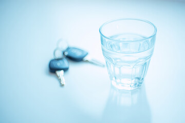 Designated driver concept with glass of water and car keys on white surface symbolizing responsibility and safety in modern lifestyle