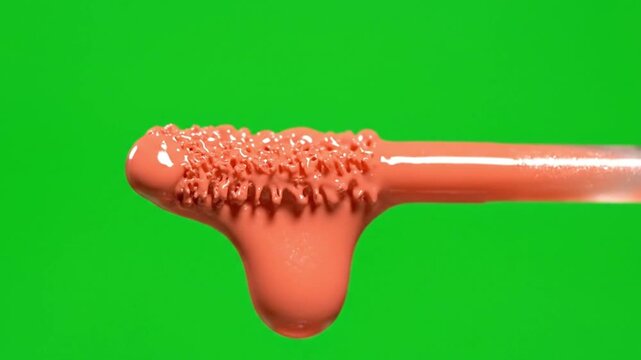 Ultra realistic close up of a dripping lip cream applicator with rich glossy texture on a vibrant green background for cosmetic branding visuals