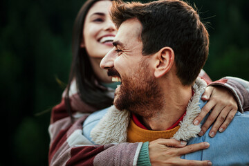 Smiling couple enjoying a piggyback ride outdoors