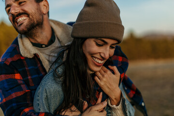 Happy couple embracing, smiling, and laughing spontaneously outdoors