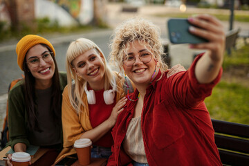 Young women friends taking selfie with smartphone