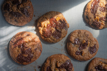 freshly baked homemade sun-dried banana bread chocolate chunk cookies on baking mat.