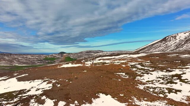 Aerial view of a scenery with partly snow covered mountains near Husavik - Iceland