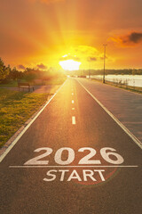 Sunrise New Year 2026 start beginnings. Start to 2026 is written on empty asphalt path with bright golden sun lights on horizon. Positivity and success of the New year 2026. Motivational background