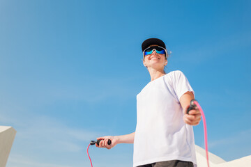 Woman skipping rope outdoors during a sunny day