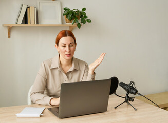 Woman podcasting with laptop and microphone at home. A popular psychologist blogger on social media holds a video meeting on his channel