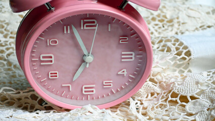 Pink alarm clock on lace 