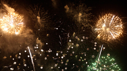 Amazing real beautiful colorful fireworks background on celebration night event for happy new year party, Abstract Multi color golden firework in the night sky