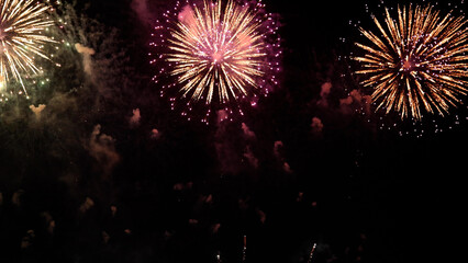 Amazing real beautiful colorful fireworks background on celebration night event for happy new year party, Abstract Multi color golden firework in the night sky