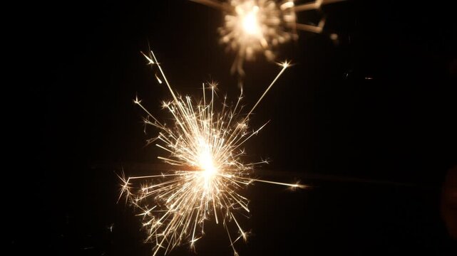 Children set off fireworks in the darkness of the night.
