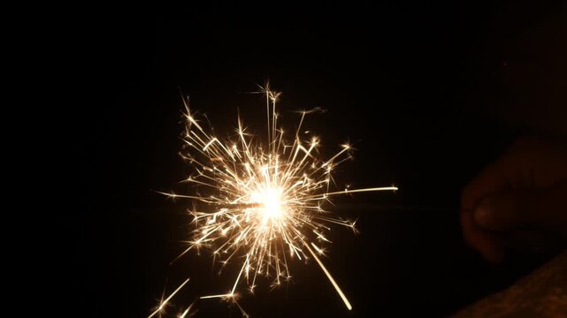 Children set off fireworks in the darkness of the night.