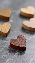 Wooden hearts scattered on a surface with a striking red heart in the center for a simple, meaningful decoration idea