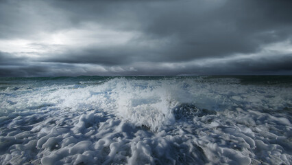 Obraz premium Dramatic landscape featuring a powerful wave crashing against the shore under a dark and moody sky. Concept of Extreme Weather