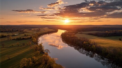 Scenic River at Golden Sunset Reflecting Sky and Clouds Over Farmland Landscape