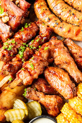A delectable assortment of sticky BBQ chicken wings, skewers, grilled sausages, and sides on a platter, ready to eat