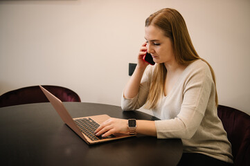 Young trader talking on phone. Analyst woman looking at laptop monitor reading bad news on financial market working in home office. Trading online investment data on stock market graph.