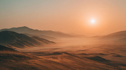 Desert landscape under a bright sun with hazy sky and distant mountain ranges casting shadows over arid sandy terrain and rolling hills at sunset time