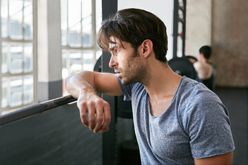 Fitness, tired or man in gym with rest, cardio training or break in intense practice. Exercise, exhausted or athlete in studio with fatigue, workout pause or breath recovery in performance goal.