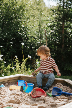 Male toddler playing in sandbox