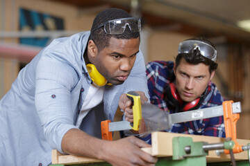 two young carpenters working in shop