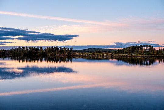 Scenic view of lake against dramatic sky at dusk
