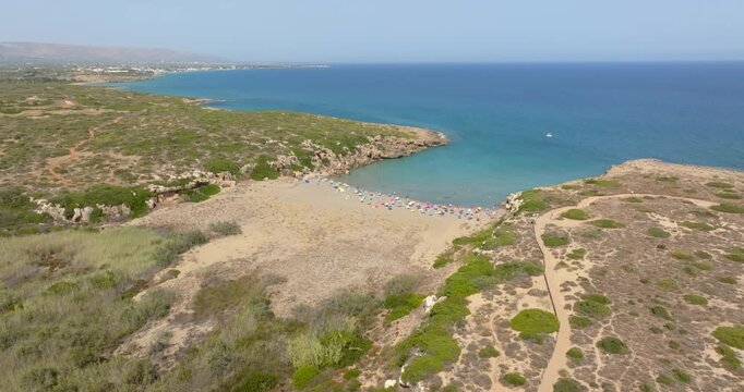 Aerial view of Cala Mosche (or Calamosche) beach, a beautiful sandy beach within the Vendicari Nature Reserve, in province of Syracuse, Sicily, Italy. It's famous for its crystal clear and blue sea.
