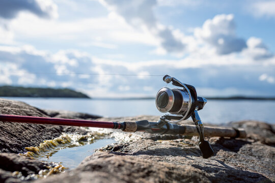 Fishing rod on lake near lake against sky