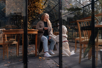 Young woman with dog in pet-friendly cafe giving paw