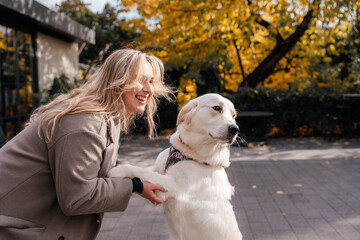 Laughing woman with golden retriever at outdoor cafe area
