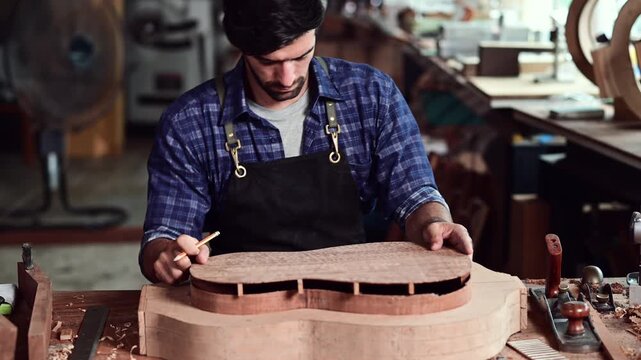 Luthier making top of guitar using traditional tools in workroom with manual tools, arts and craft concept.	
