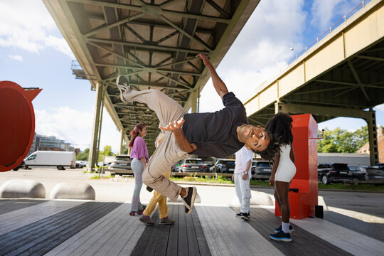 Mid-air shot of young man doing somersault on platform