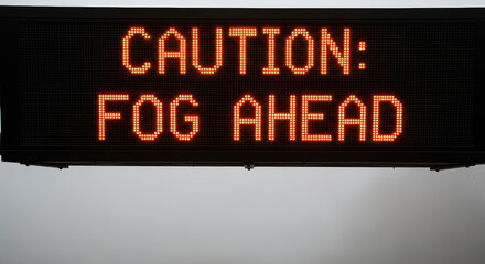 An electronic LED sign displays a "Caution: Fog Ahead" warning. A digital traffic display for road safety and weather alerts with copy space