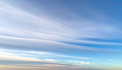 巻層雲がうすぐものように青空を覆い淡い光が地平線に伸びる穏やかな風景